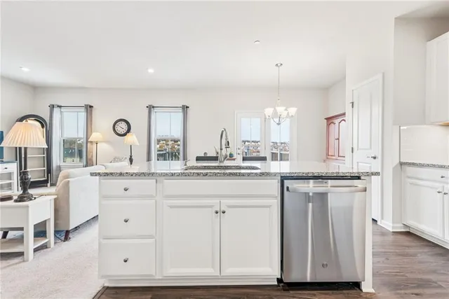 a kitchen with granite countertop white cabinets and white appliances
