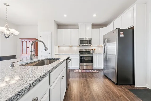 a kitchen with stainless steel appliances granite countertop a kitchen island hardwood floor sink and stove