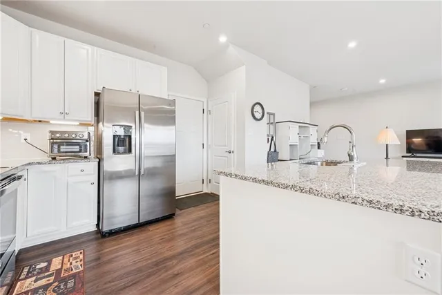 a kitchen with granite countertop a refrigerator and a sink