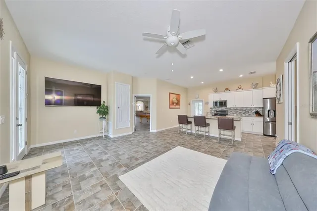 a living room with furniture and a view of kitchen