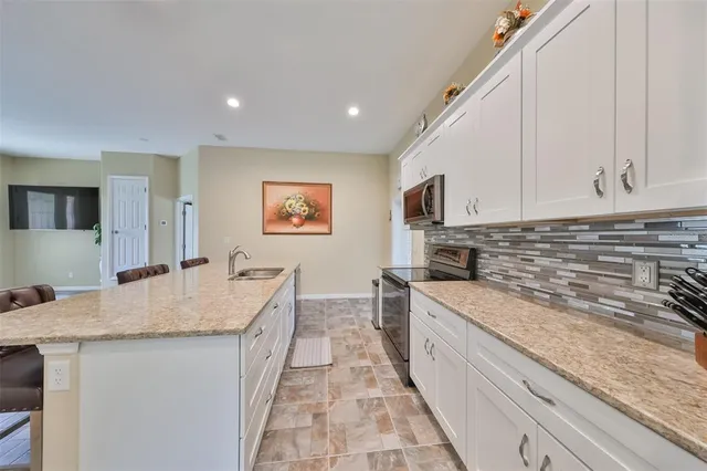 a large kitchen with granite countertop a sink and dishwasher stove top oven