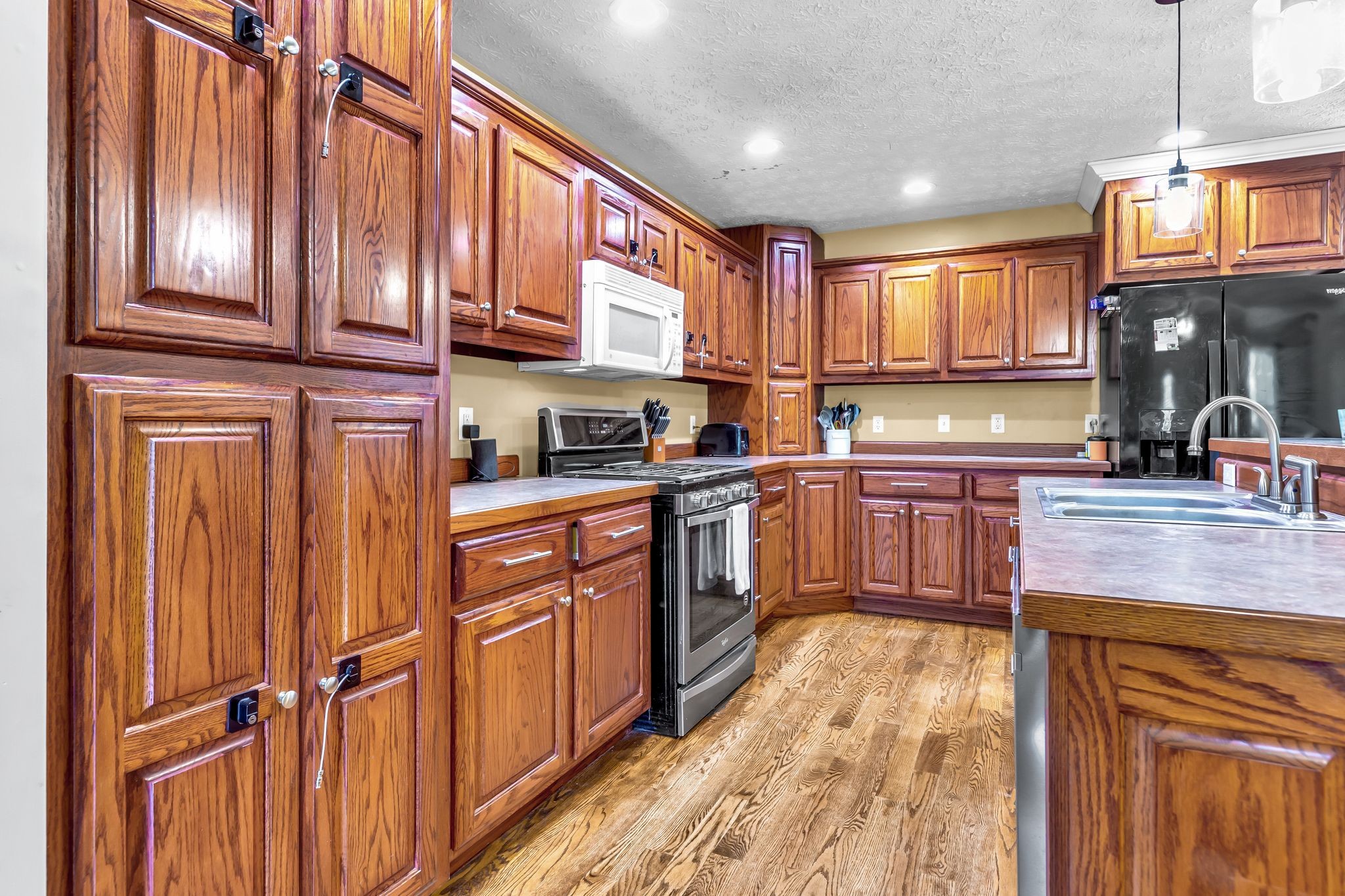 1450 Pleasant Hill Road McMinnville, TN 37110 - Photo 10 of 33 a kitchen with stainless steel appliances granite countertop wooden cabinets a sink and dishwasher a refrigerator with wooden floor