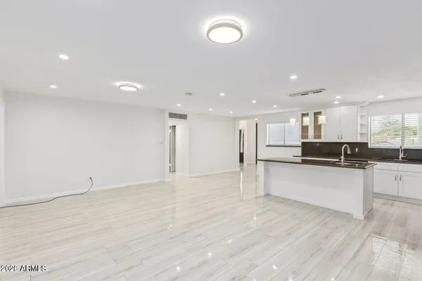 a large kitchen with stainless steel appliances a large counter top and a wooden floor