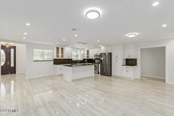 a large kitchen with stainless steel appliances kitchen island a large counter top and a stove top oven