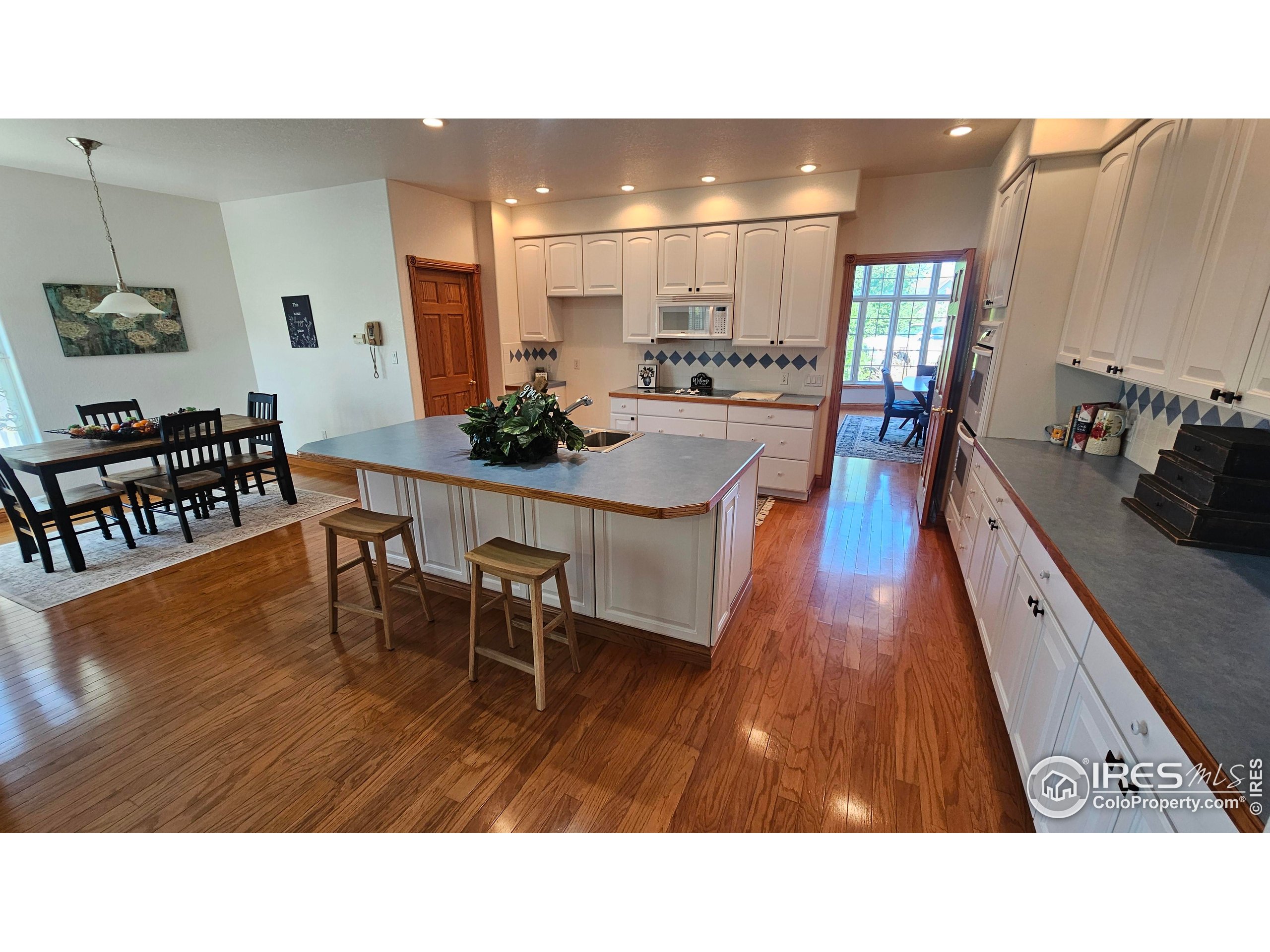 17606 County Rd Q.8 Fort Morgan, CO 80701 - Photo 17 of 37 a living room with stainless steel appliances kitchen island granite countertop a table chairs and a sink