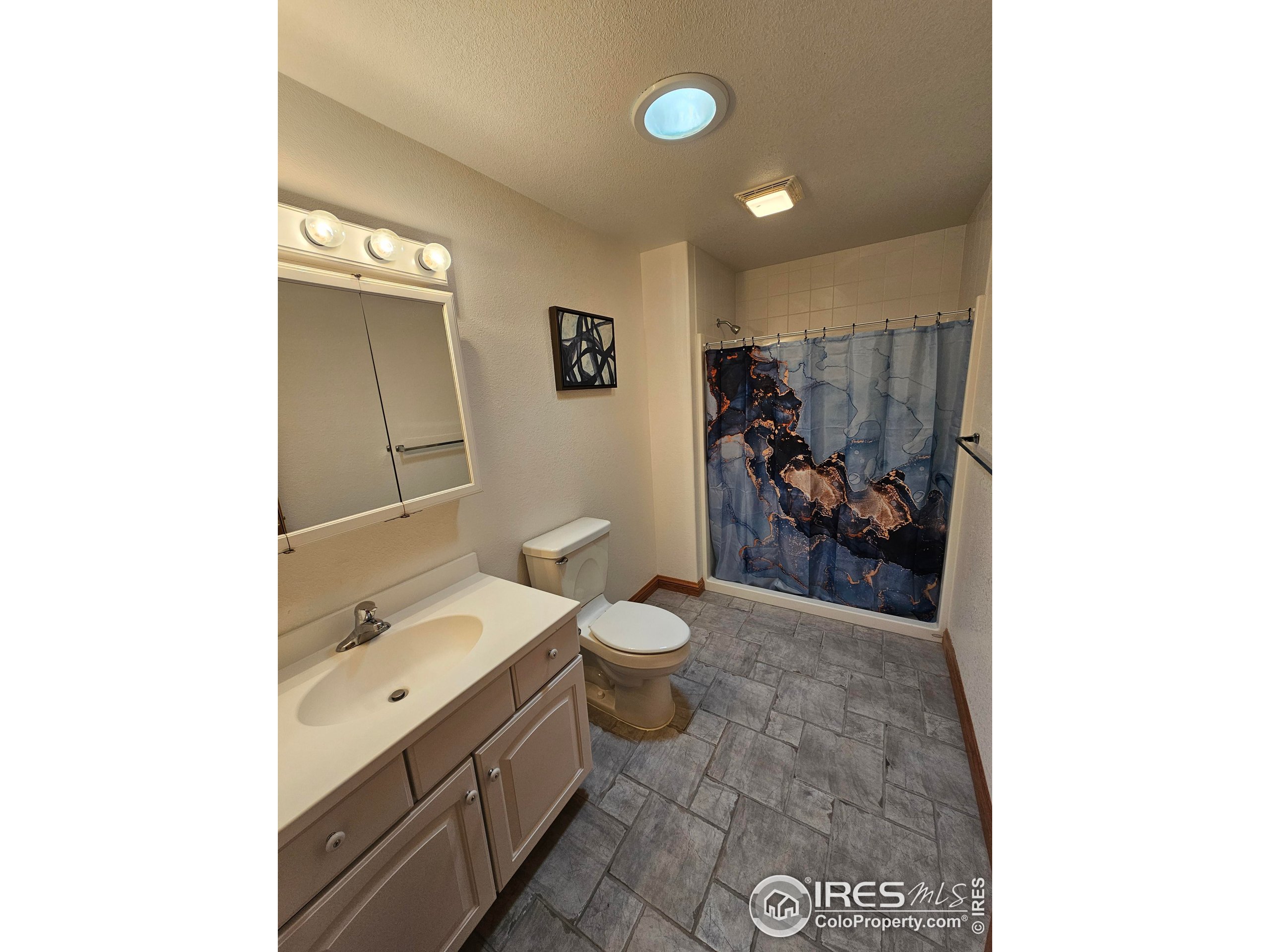17606 County Rd Q.8 Fort Morgan, CO 80701 - Photo 27 of 37 a bathroom with a toilet sink and mirror