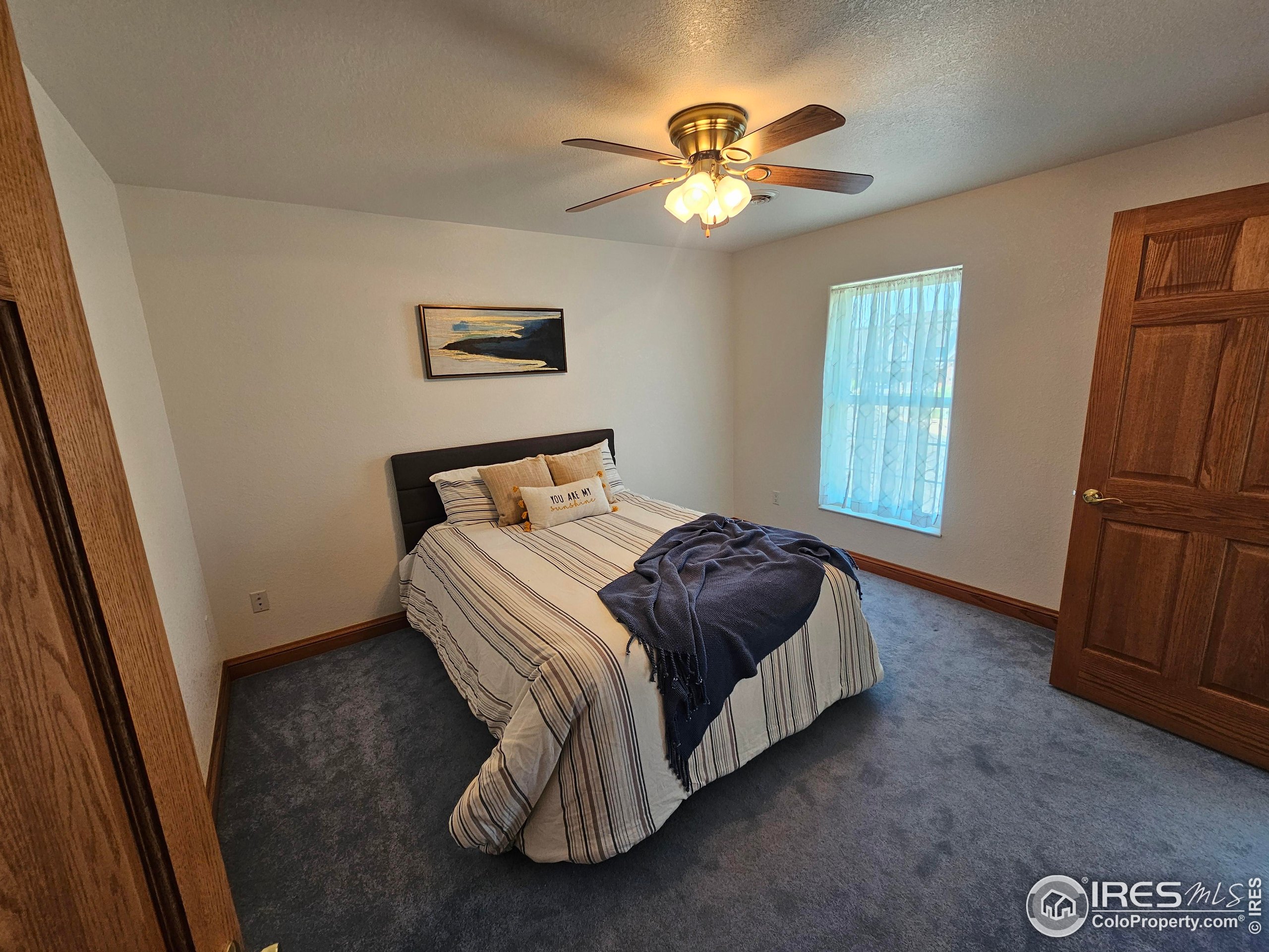 17606 County Rd Q.8 Fort Morgan, CO 80701 - Photo 28 of 37 a bedroom with a bed and a chandelier