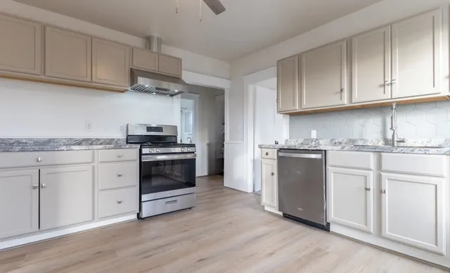 a kitchen with granite countertop a stove and a sink