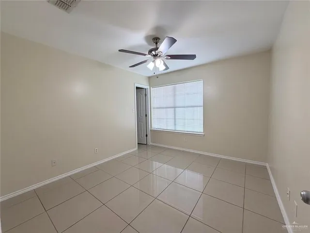 an empty room with windows and fan