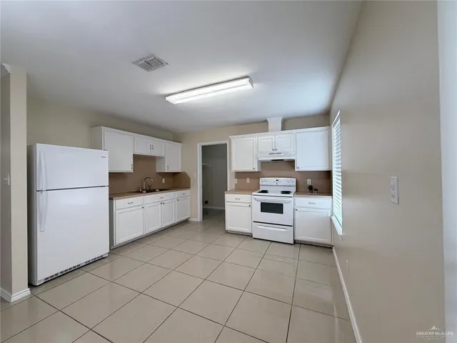 a kitchen with cabinets and white appliances