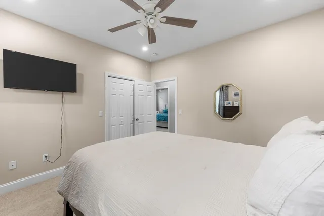 a bedroom with a large bed and a flat tv screen