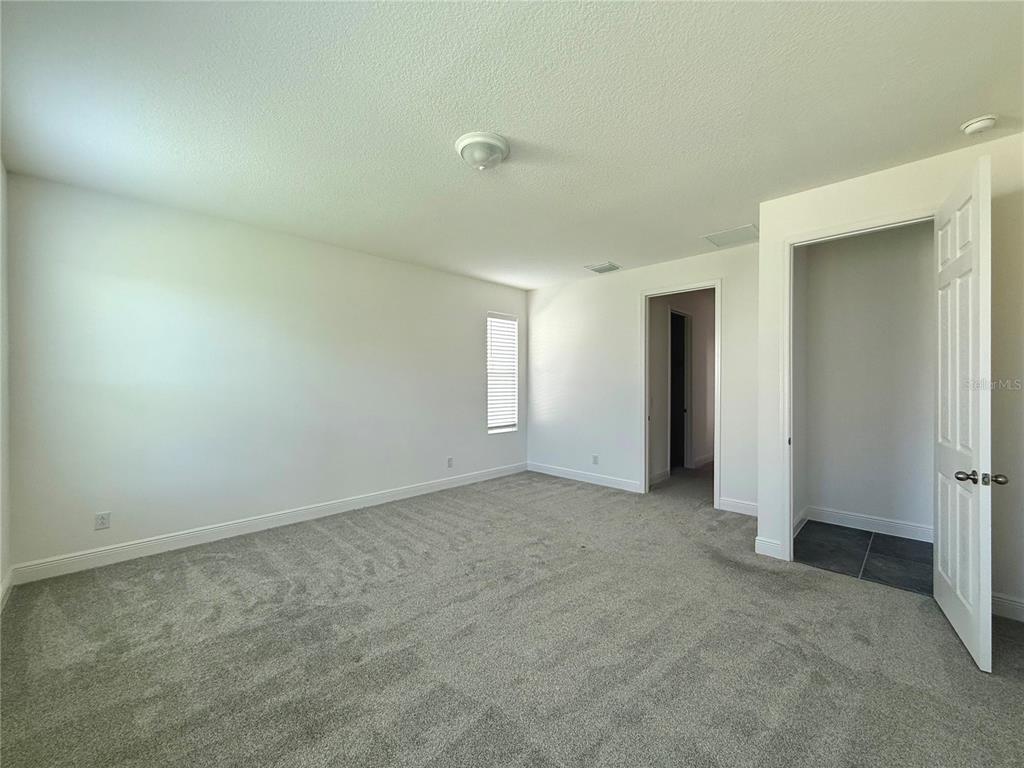 394 Switchgrass Loop Minneola, FL 34715 - Photo 20 of 26 an empty room with windows and closet