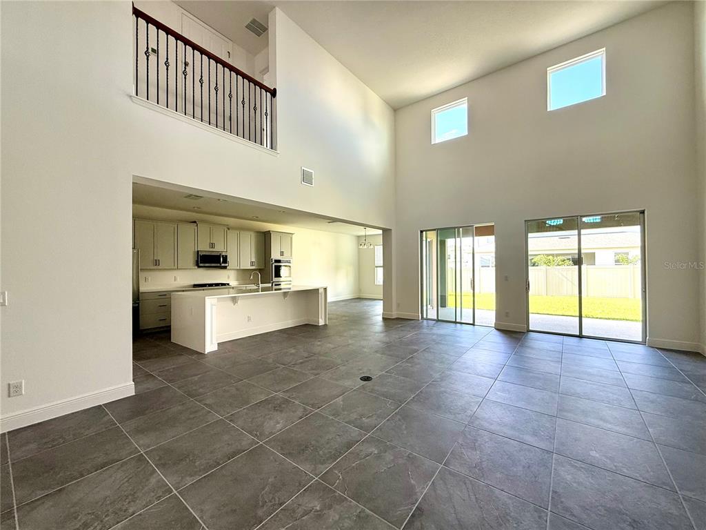 394 Switchgrass Loop Minneola, FL 34715 - Photo 3 of 26 a view of an empty room with a kitchen
