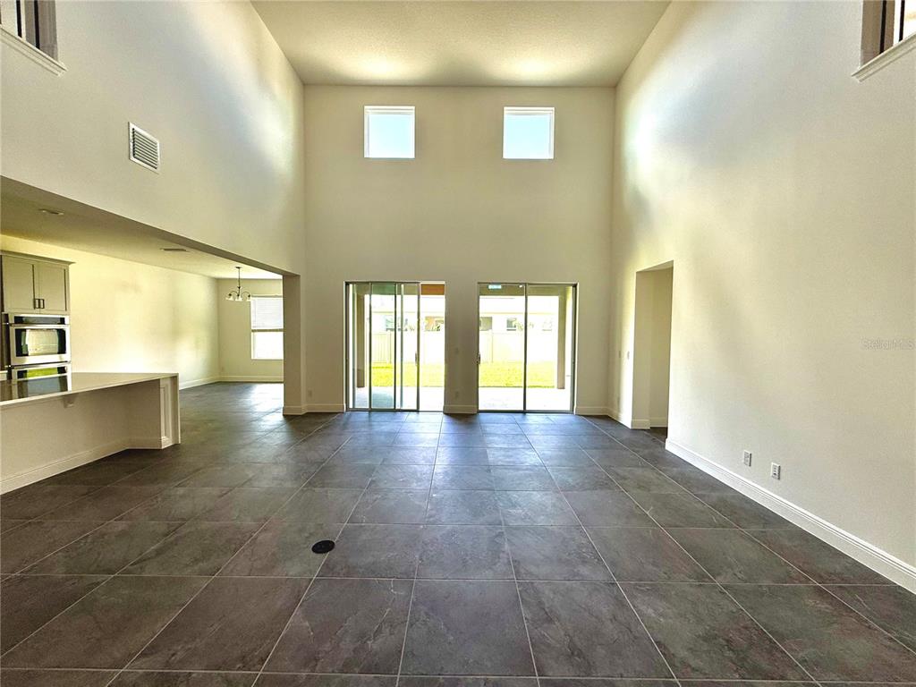 394 Switchgrass Loop Minneola, FL 34715 - Photo 7 of 26 a view of an empty room with window and wooden floor