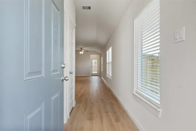 a view of a hallway with wooden floor and staircase