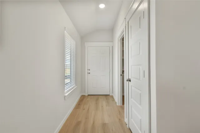 a view of a room with wooden floor and a bathroom