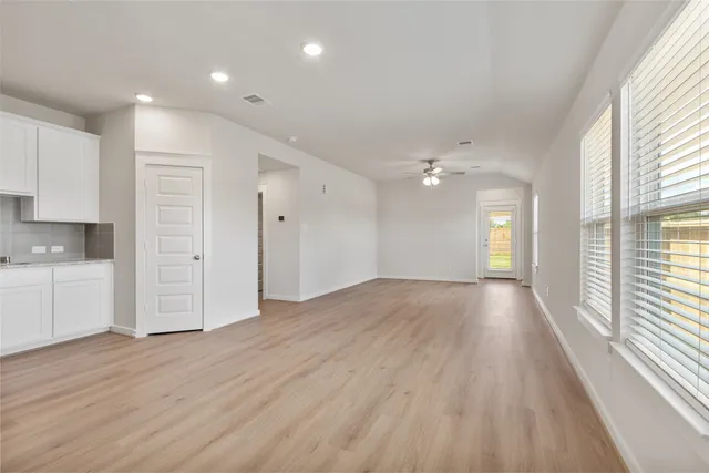 a view of empty room with wooden floor and window