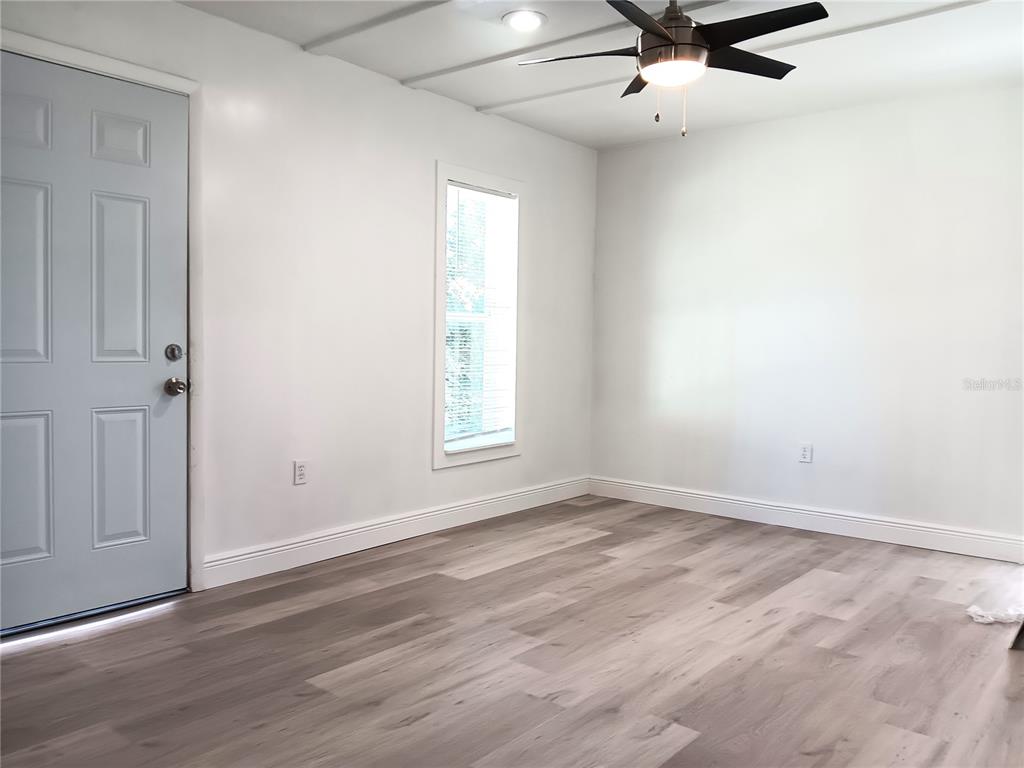 885 Beltrees Street, Unit 15 Dunedin, FL 34698 - Photo 2 of 12 wooden floor in an empty room with a window