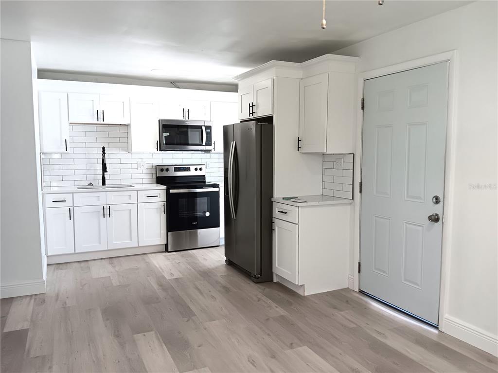 885 Beltrees Street, Unit 15 Dunedin, FL 34698 - Photo 4 of 12 a kitchen with stainless steel appliances a refrigerator sink and cabinets