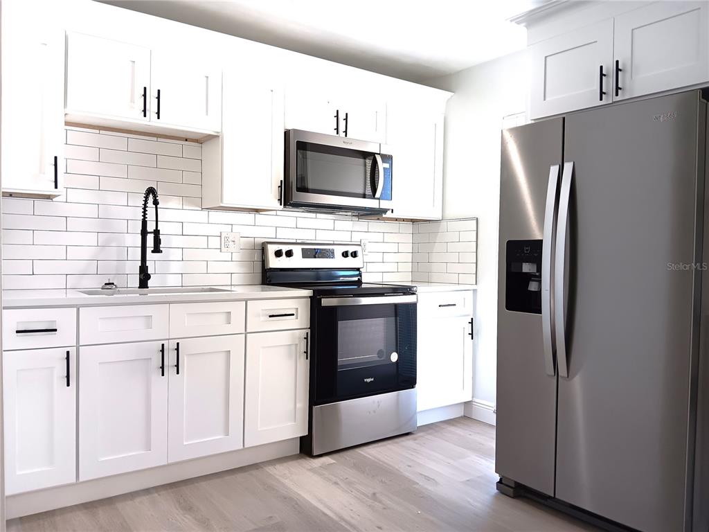 885 Beltrees Street, Unit 15 Dunedin, FL 34698 - Photo 5 of 12 a kitchen with stainless steel appliances a refrigerator stove and microwave