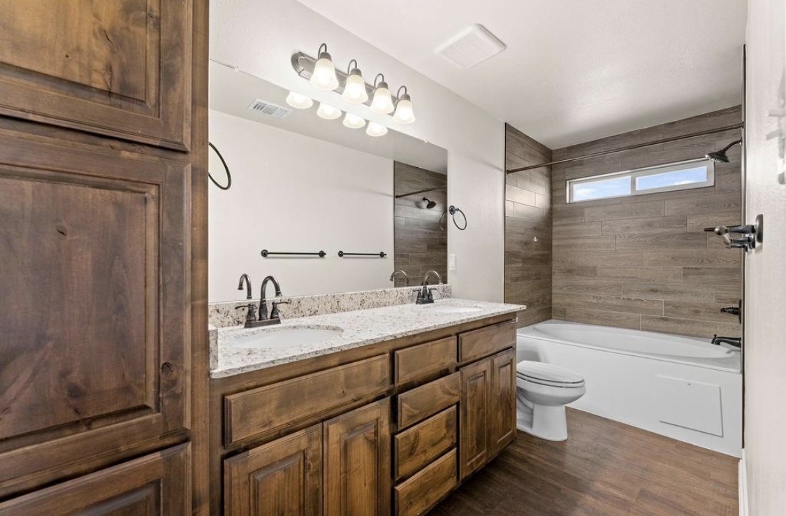 113 Calvin Smith Ln. Lane Jarrell, TX 76537 - Photo 13 of 16 a bathroom with a double vanity sink toilet and shower