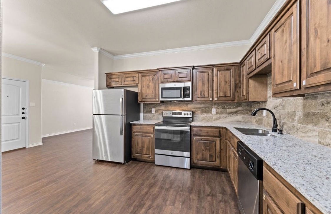 113 Calvin Smith Ln. Lane Jarrell, TX 76537 - Photo 4 of 16 a kitchen with a sink cabinets stainless steel appliances and a counter space