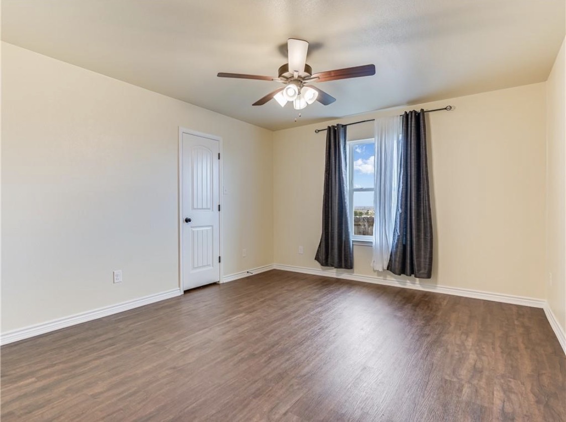 113 Calvin Smith Ln. Lane Jarrell, TX 76537 - Photo 6 of 16 a view of an empty room with wooden floor and a ceiling fan
