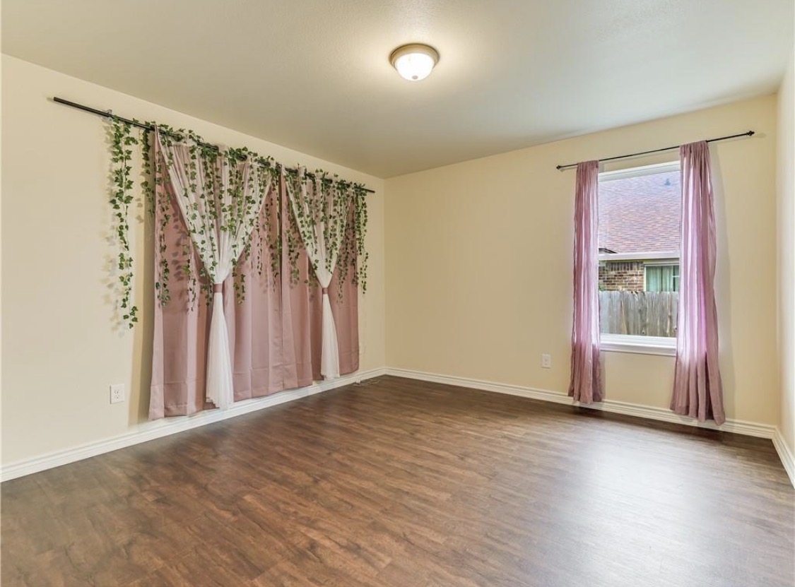 113 Calvin Smith Ln. Lane Jarrell, TX 76537 - Photo 9 of 16 an empty room with wooden floor and a window