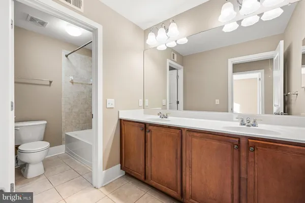 a bathroom with a granite countertop sink a toilet and a mirror