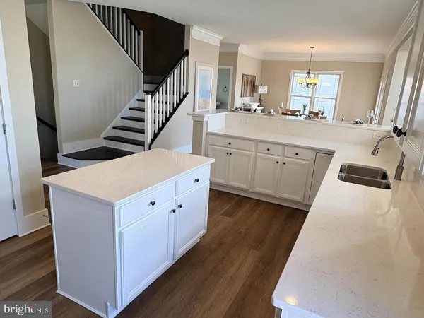a kitchen with cabinets and wooden floor