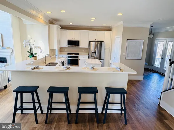 a kitchen with stainless steel appliances granite countertop a kitchen island a stove a table and chairs with wooden floor