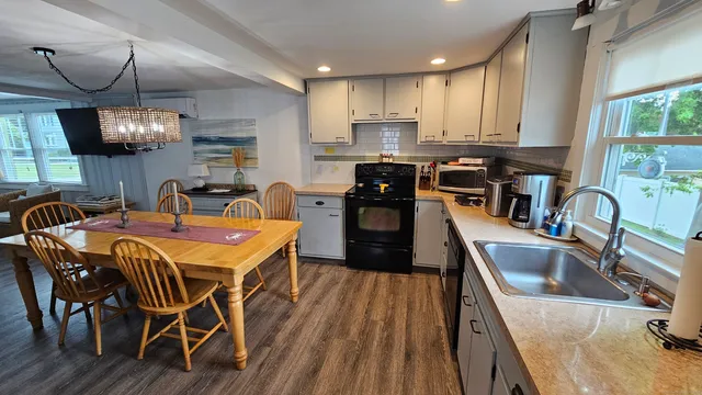 a kitchen with stainless steel appliances granite countertop a kitchen island a stove a sink a dining table and chairs