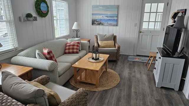 a living room with furniture a window and wooden floor