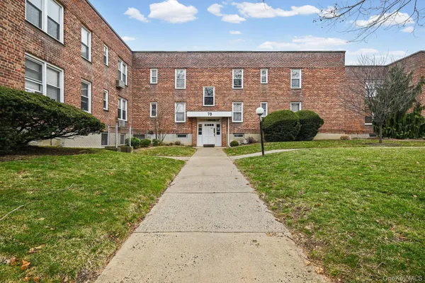 a front view of a brick house with a yard