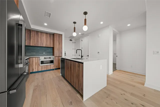 a kitchen with kitchen island granite countertop a large counter top and stainless steel appliances