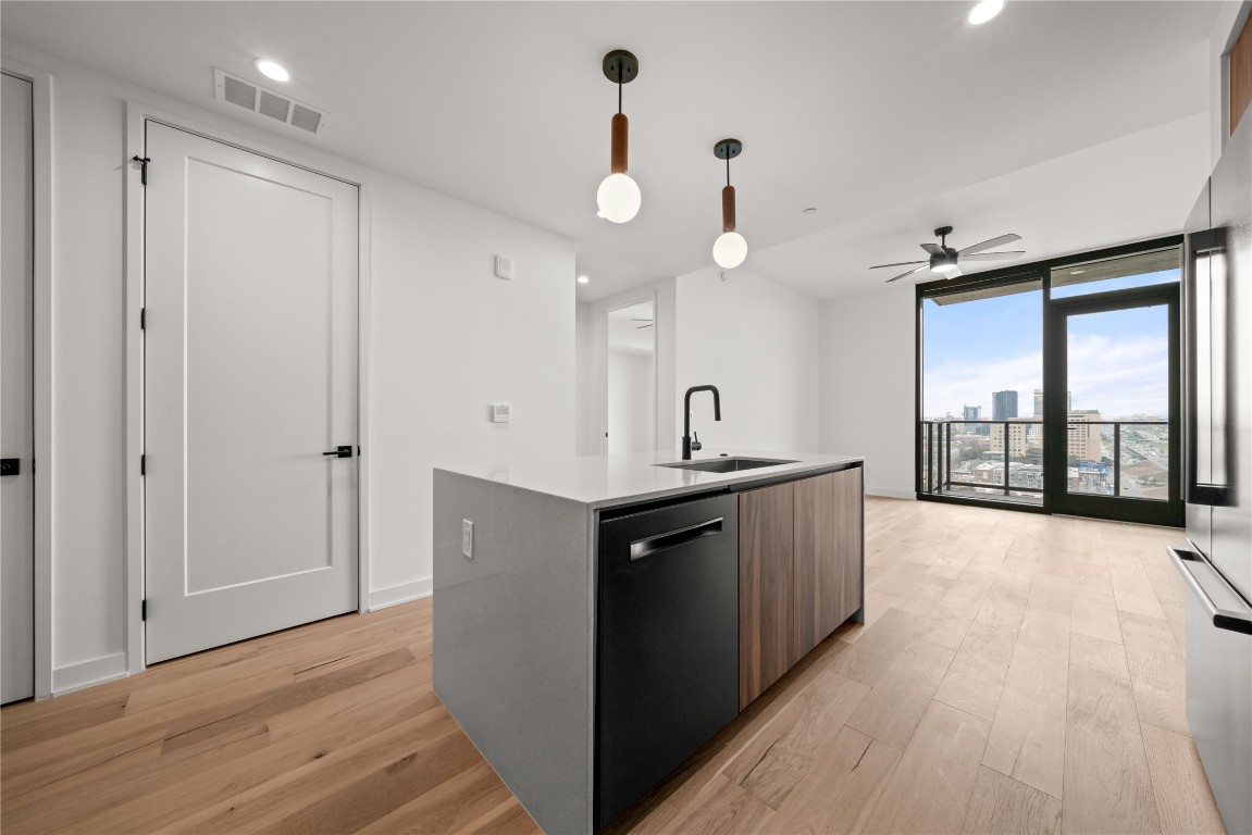 84 East Avenue, Unit 1708 Austin, TX 78701 - Photo 4 of 29 Representative Photo. Kitchen featuring Concrete tile backsplash, The kitchen features waterfall-edge terrazzo countertops for a sleek, modern look, Black Stainless Steel Bosch Appliances, Pendant lighting above Kitchen Island.
