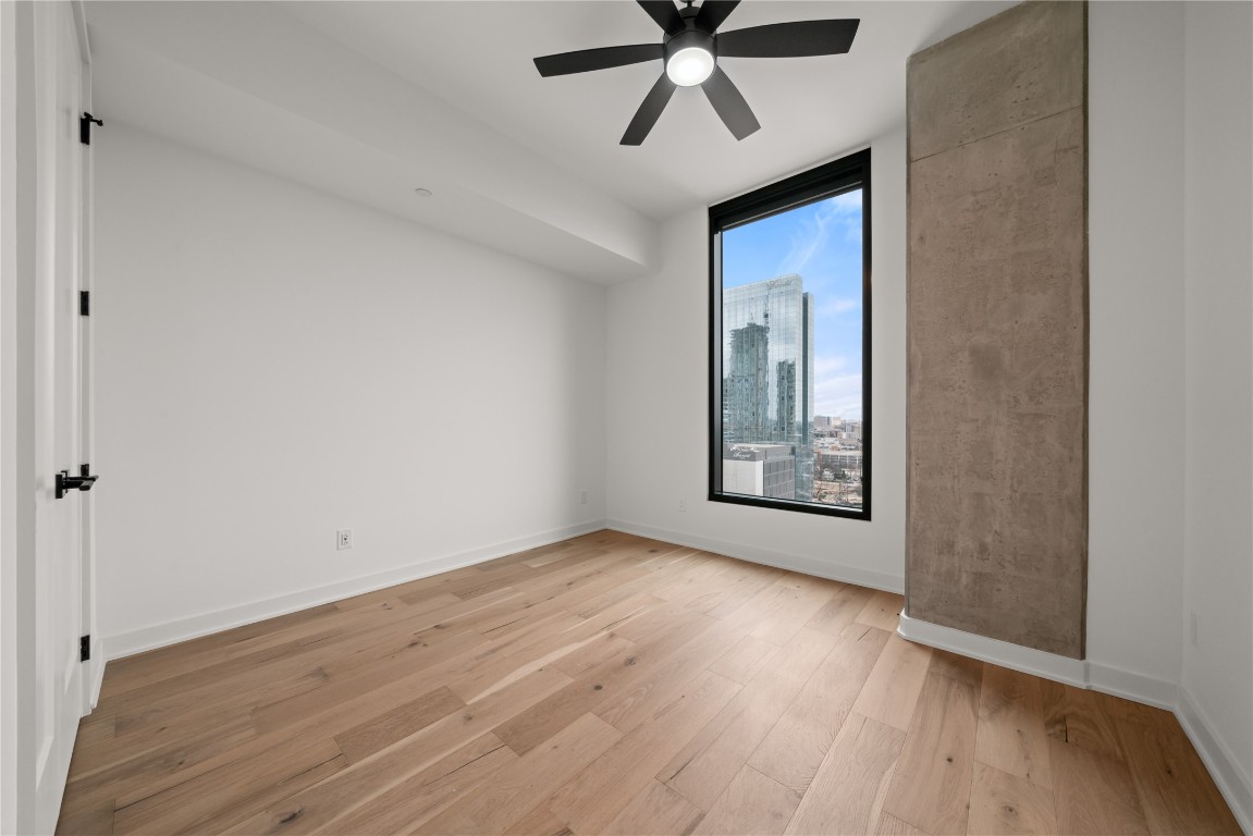 84 East Avenue, Unit 1708 Austin, TX 78701 - Photo 9 of 29 Representative Photo. Primary Bedroom with wood flooring, large window, ceiling fan, and window treatments included