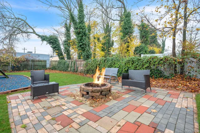 a view of a table and chairs in backyard of the house