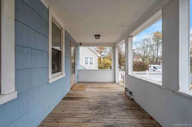 a view of a porch with wooden floor and windows