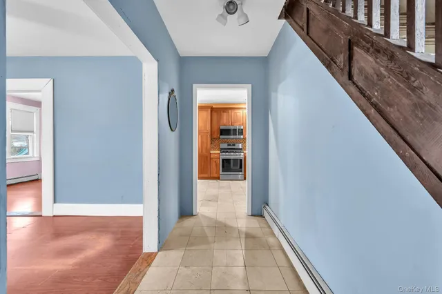a view of a hallway with wooden floor and staircase