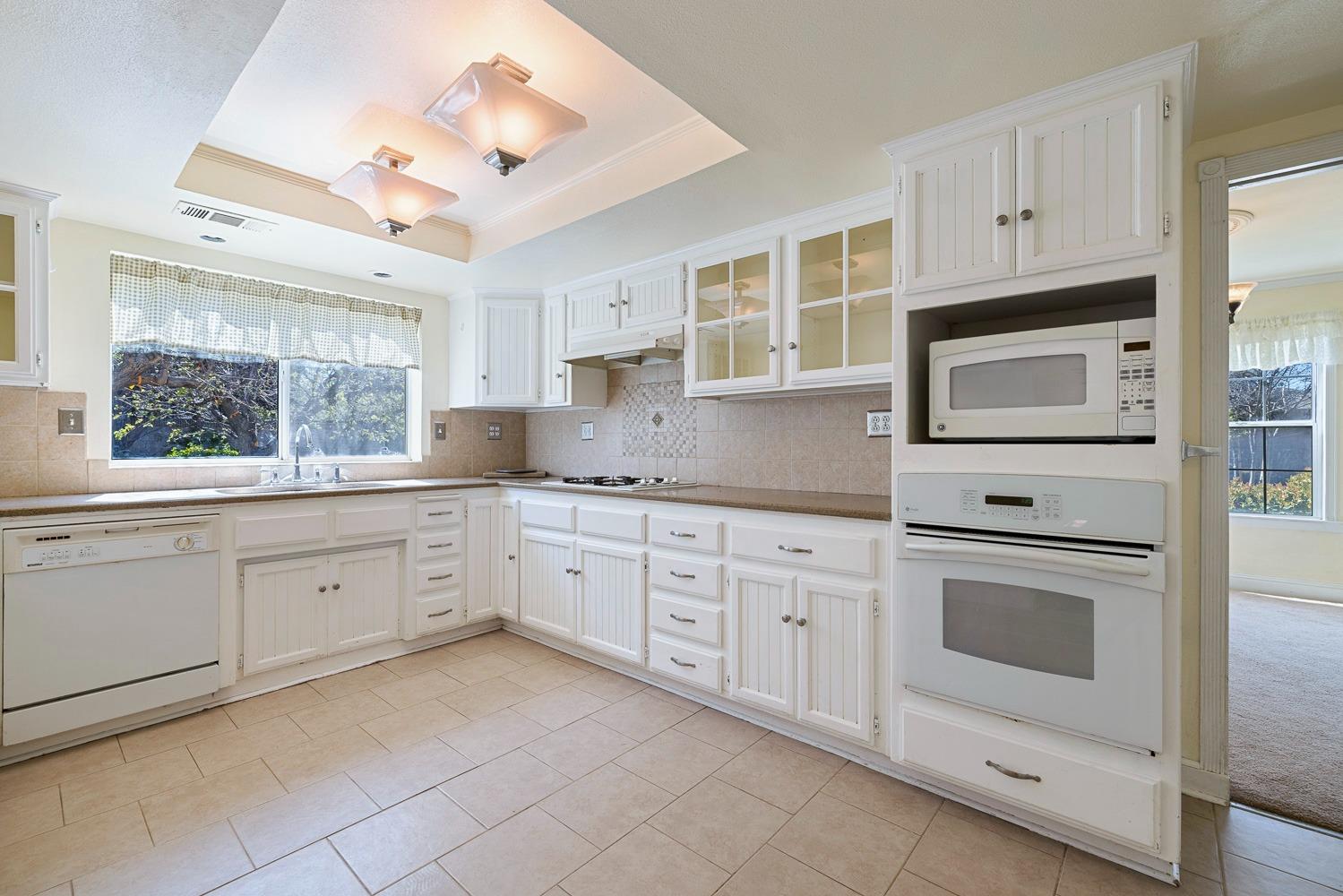 695 Monroe Street Coalinga, CA 93210 - Photo 13 of 44 a kitchen with granite countertop white cabinets white stainless steel appliances with a sink and dishwasher