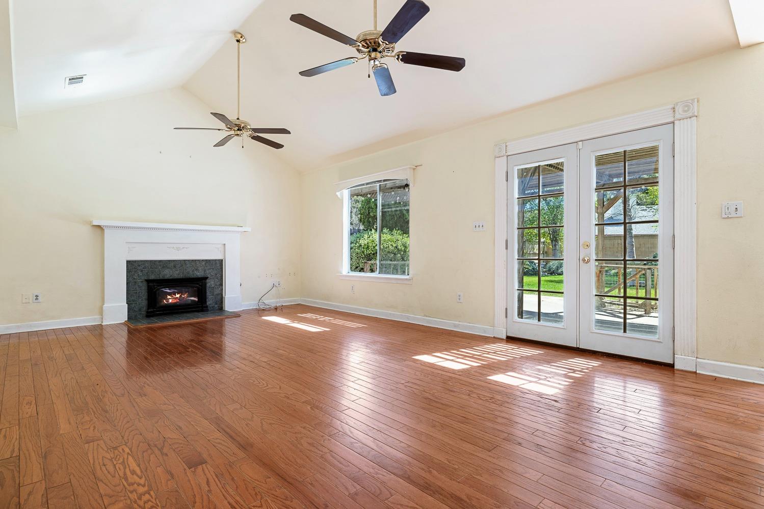 695 Monroe Street Coalinga, CA 93210 - Photo 18 of 44 a view of an empty room with wooden floor fireplace and a window