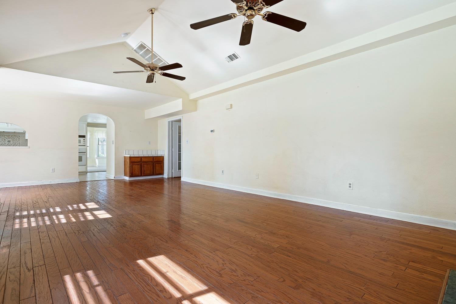 695 Monroe Street Coalinga, CA 93210 - Photo 20 of 44 a view of an empty room with a window and wooden floor