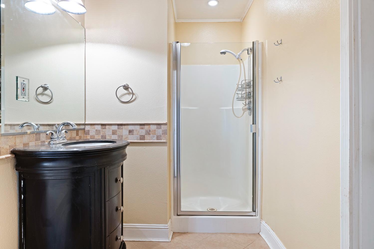 695 Monroe Street Coalinga, CA 93210 - Photo 22 of 44 a bathroom with a sink a mirror and shower
