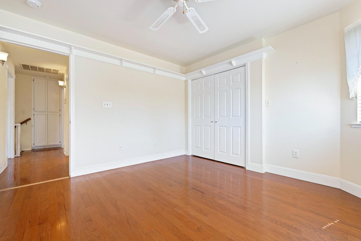 695 Monroe Street Coalinga, CA 93210 - Photo 31 of 44 an empty room with wooden floor and a ceiling fan