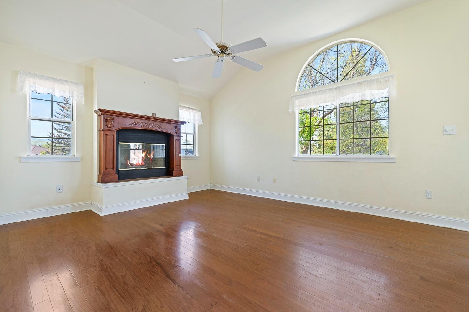 695 Monroe Street Coalinga, CA 93210 - Photo 32 of 44 an empty room with wooden floor a ceiling fan and windows