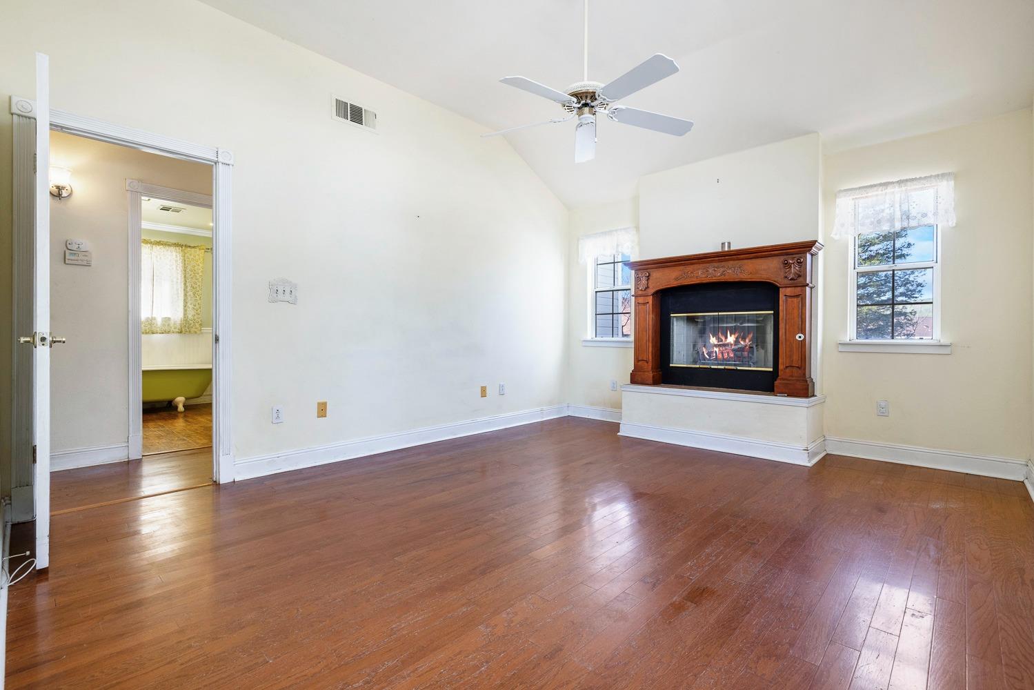 695 Monroe Street Coalinga, CA 93210 - Photo 33 of 44 an empty room with wooden floor a fireplace and a window