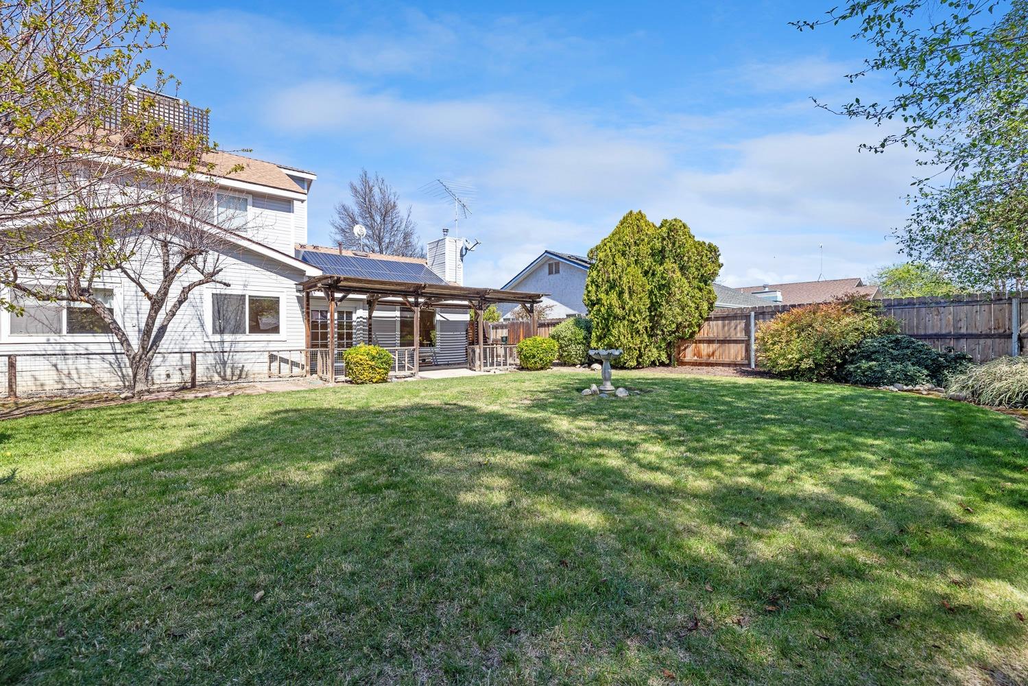 695 Monroe Street Coalinga, CA 93210 - Photo 43 of 44 a view of a white house with a big yard plants and large trees