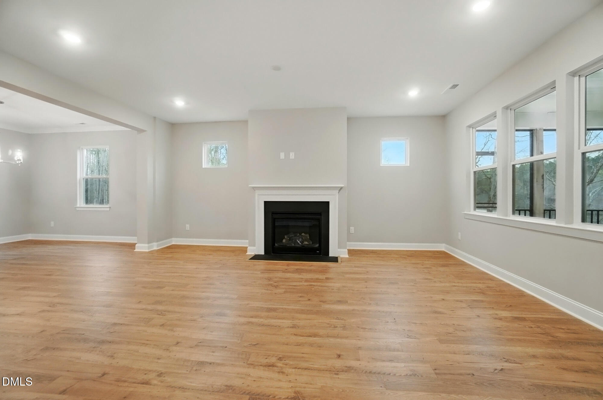 285 Gilliland Road Siler City, NC 27344 - Photo 9 of 45 an empty room with wooden floor and a fireplace