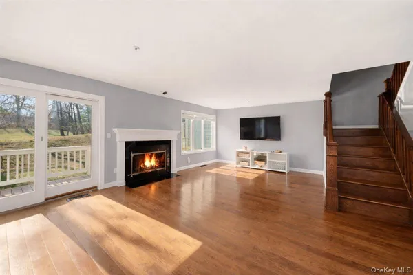 a view of a livingroom with wooden floor and a fireplace